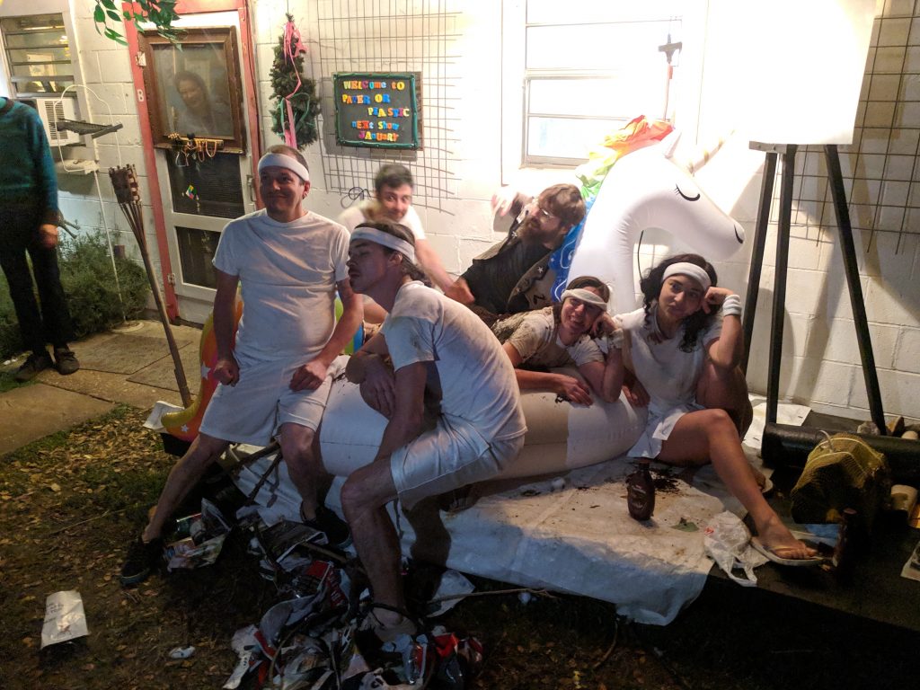 Collection Rert performers posing on an inflatable unicorn in front of the gallery.