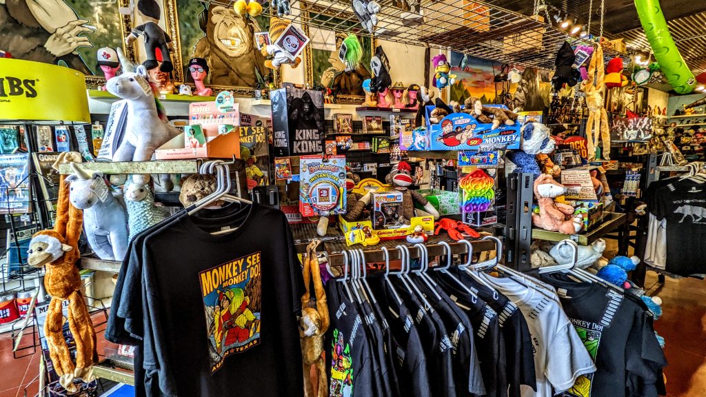 Interior of the 'Monkey See Monkey Do' shop showcasing a collection of t-shirts, stuffed animals, and playful toys.
